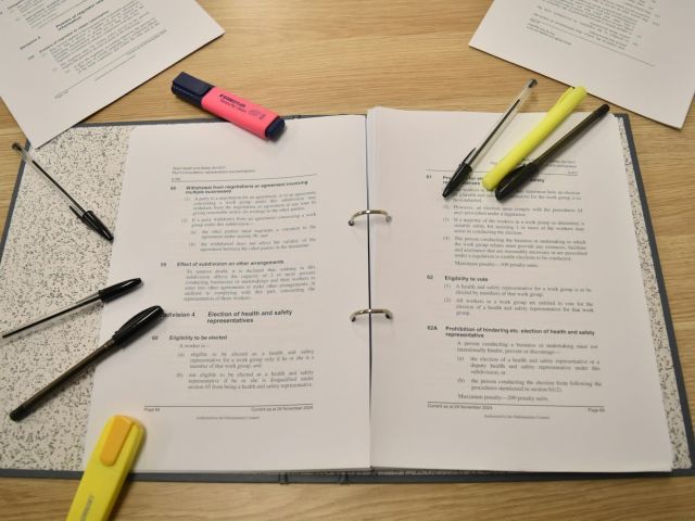 Binder highlighters Open ring binder of legislation with pens and highlighters