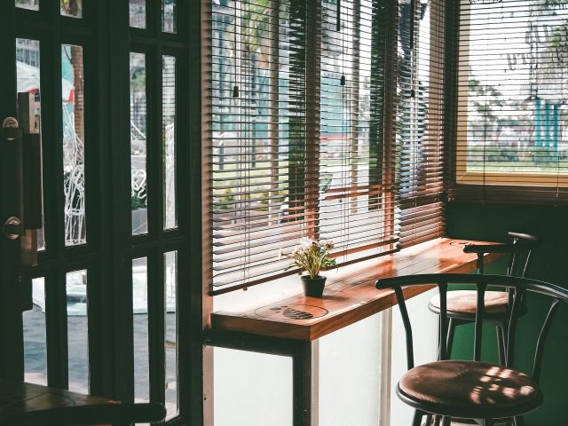 Cafe window seat Window seat in a quiet cafe with timber stools and venetian blinds