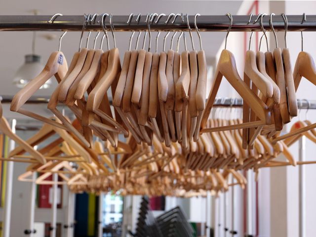 Clothes hangers on a rail Rows of timber coat hangers on a rail in a clothing shop